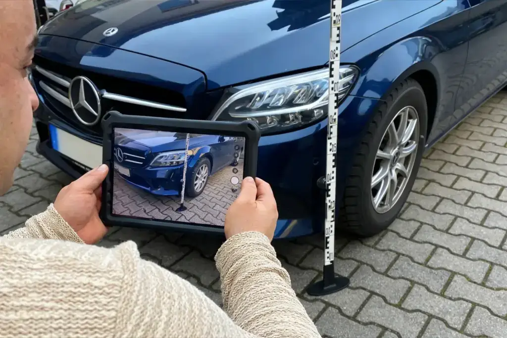 Schadengutachten in Hamburg – digitale Schadenaufnahme an einem Pkw mit Tablet und Messlatte zur präzisen Fahrzeugbewertung